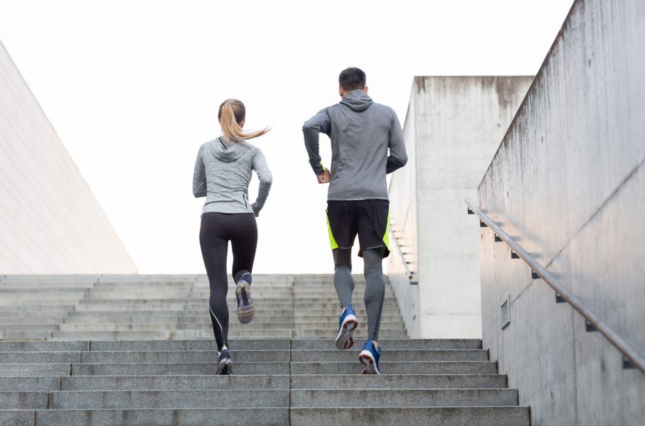 Couple running up concrete stairs